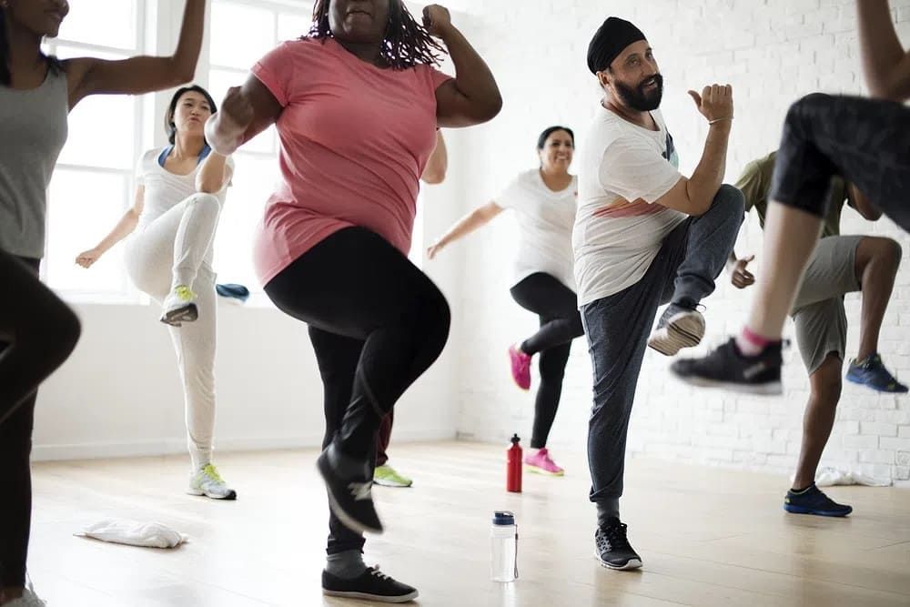A group of people doing aerobics in the gym.